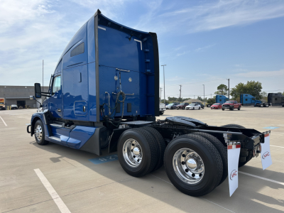Kenworth T680 tractor rear side view showing tandem rear wheels and blue cab.