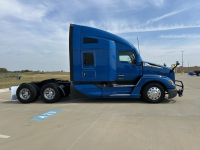Kenworth T680 truck side view in blue showing sleeper cab, rear tandem wheels, fuel doors, and side mirror. Visible text: none legible on this edge.