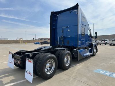 Kenworth T680 tractor in blue, rear/side view, showing dual rear axles, chrome wheels, and sleeper cab, no visible text on image aside from context stock numbers.