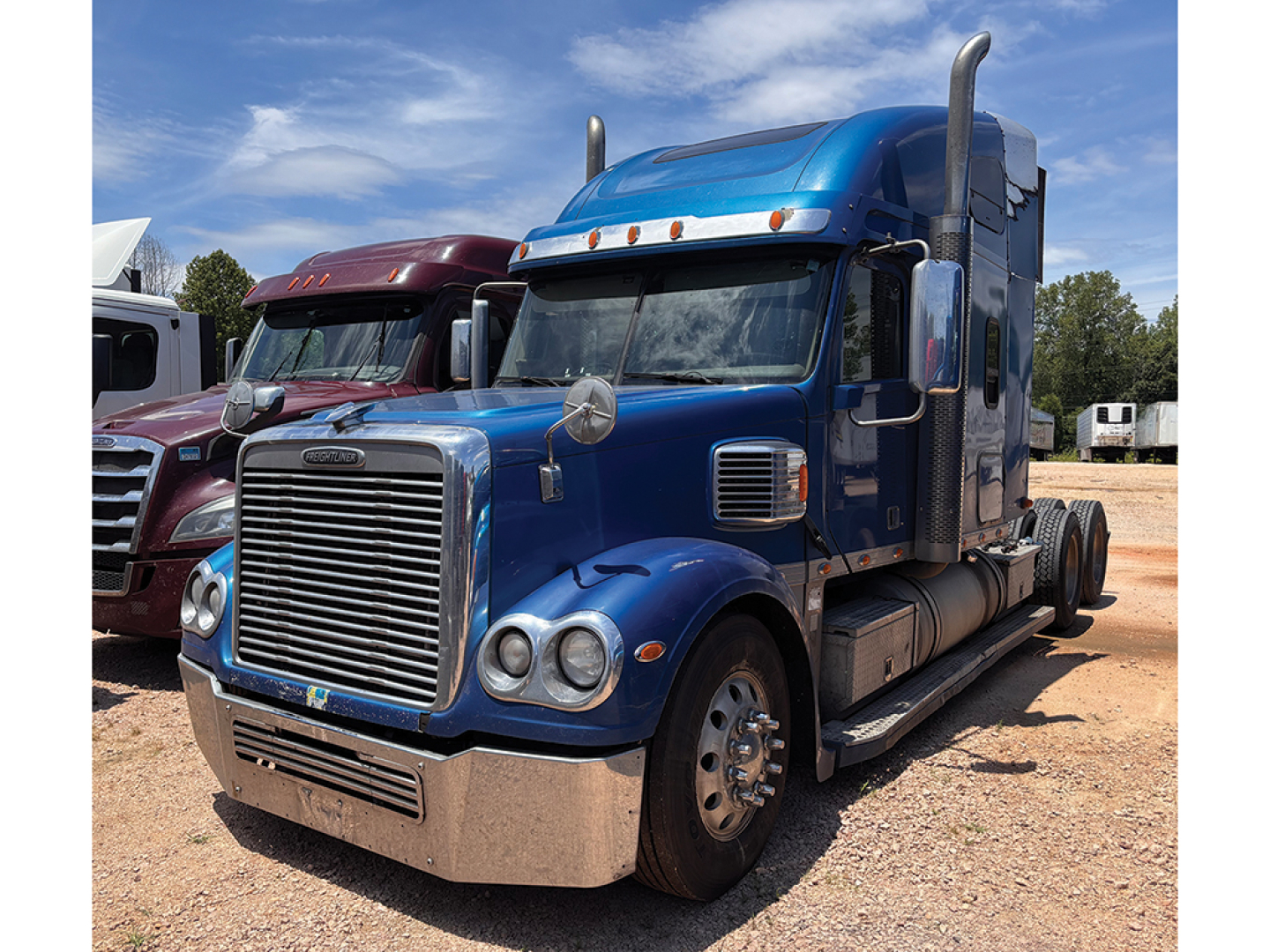 2016 Freightliner Coronado tractor truck in blue front three-quarter view showing chrome grille and hood, 18-wheel sleeper cab.
