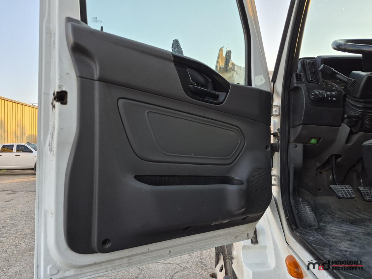 Truck interior door panel and cab entry showing part of cab interior and floor mats.