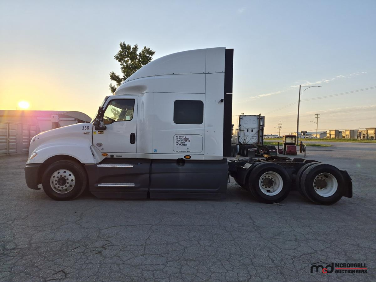 Truck cab side view showing International LT625 Sleeper tractor with white paint and black lower trim.
