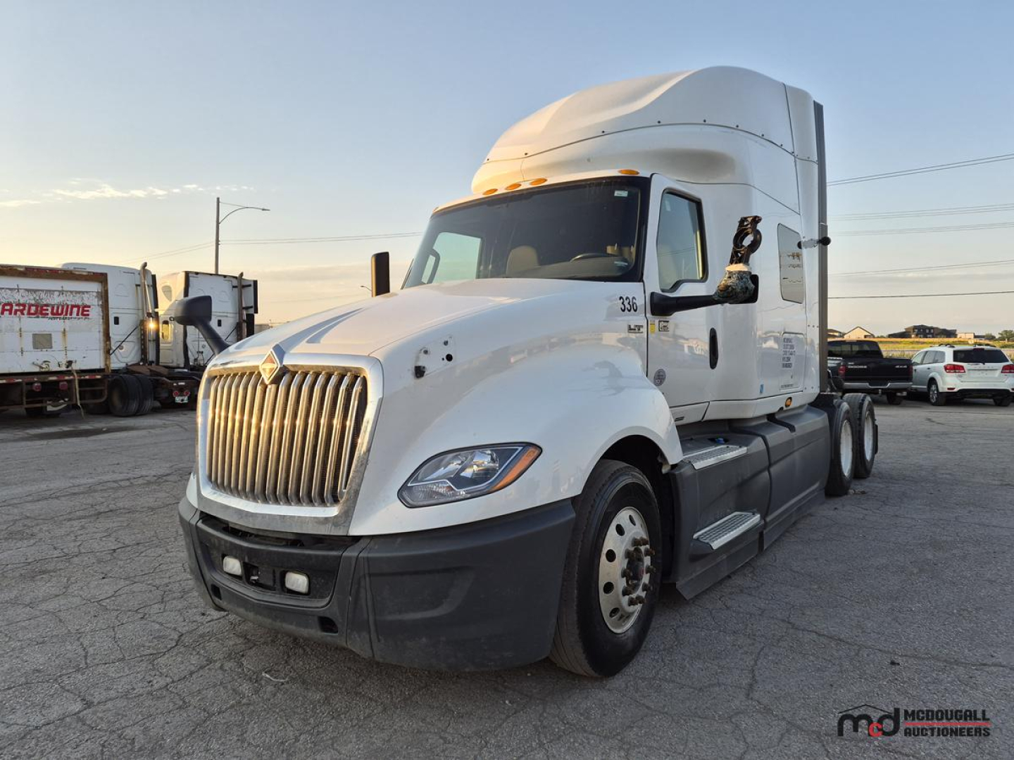 Truck cab showing International LT625 Sleeper tractor with white exterior, chrome grille, dual rear axles, and sleeper cab.