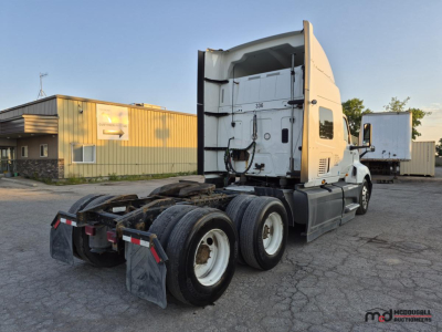 2021 International LT625 T/A Sleeper Semi Truck in a used lot. Rear view shows dual rear axles, mud flaps, and sleeper cab with door and open cargo area. 