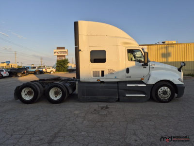 Truck side view showing 2021 International LT625 T/A sleeper tractor with white cab, dual rear axles, and fuel tanks.