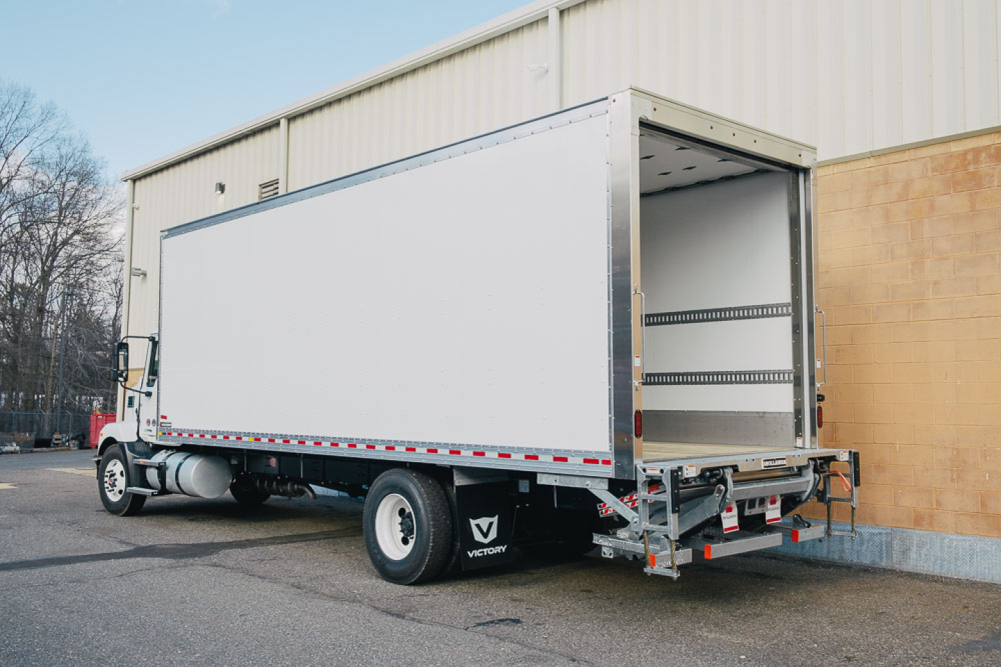 Box truck rear and side view showing cargo area and rear doors with open access, Mack MD6 in-service vehicle.