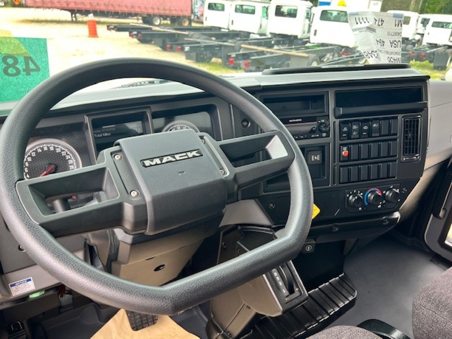 Mack MD6 truck interior showing steering wheel and dashboard with gauges and control panel.