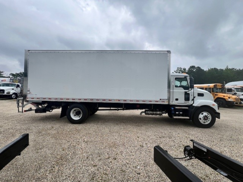 Mack MD6 box truck in side profile showing cab and large cargo box with white exterior and rear double-axle configuration.