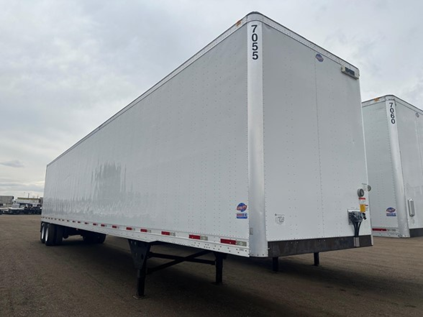 Trailer side view of 2018 Utility 4000Dx van trailer showing white aluminum exterior and rear doors.