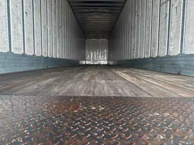 Trailer interior view of a 2018 Utility 4000Dx, empty cargo space with metal diamond plate threshold and corrugated side walls.