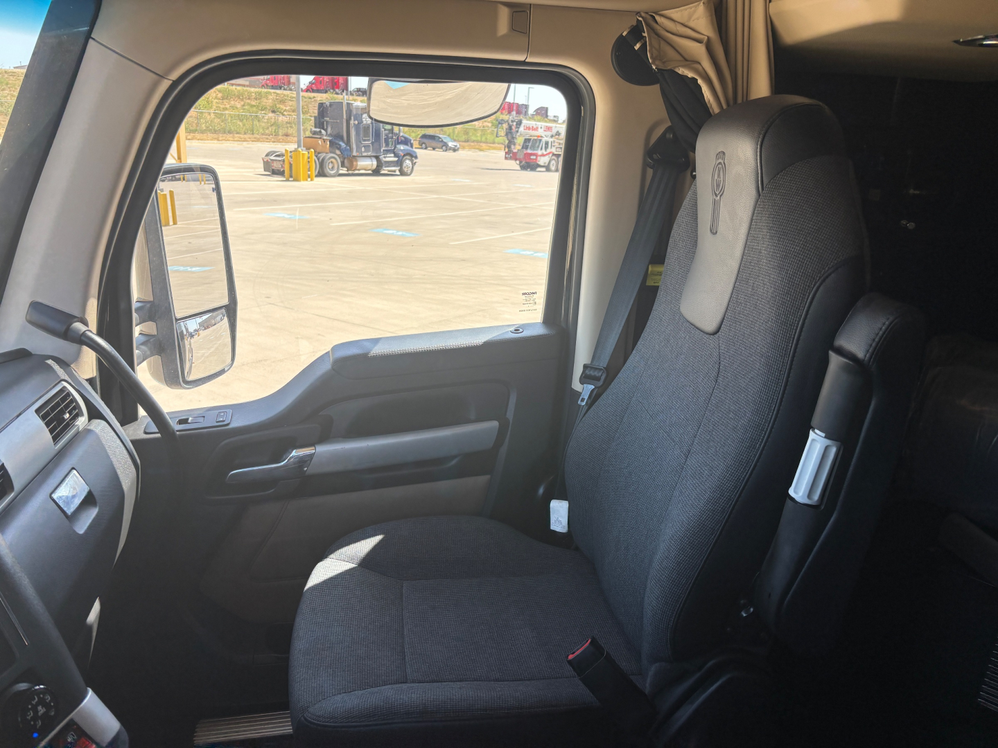 Kenworth T680 truck cab interior showing driver seat and dashboard area.