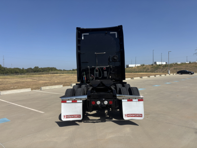 Kenworth T680 rear view showing chassis and mud flaps with Kenworth branding, fifth wheel area, and exhaust routing.