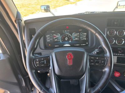Volvo? No, Kenworth T680 steering wheel and instrument cluster visible, with round gauges and digital display behind steering wheel.