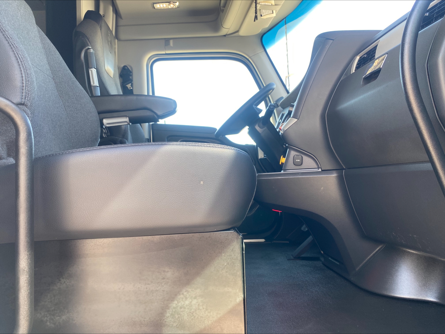 Kenworth T680 interior cab view showing driver seat and dashboard from passenger side.