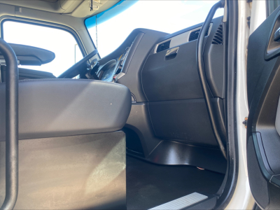 Truck cab interior of a Kenworth T680 with steering wheel, dashboard, and front seats visible from the open driver side door.