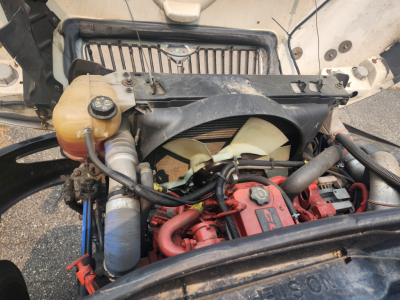 Engine bay of 2020 International MV607 with radiator, coolant reservoir, turbo/intercooler piping, and red-painted engine block.