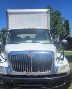 Front view of 2020 International MV607 box truck showing chrome grille, International emblem, bumper, and side mirrors.