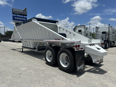 Dump trailer with dual rear axles and white steel bed, side rails, and a raised gooseneck, viewed from the rear-left in a dealership lot.