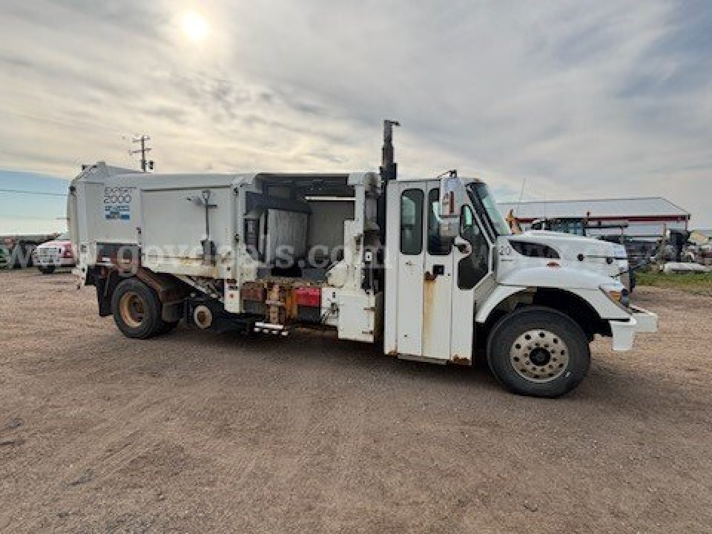International 7400 garbage truck side view showing dump body and cab, VIN 1HTWCAZR1BJ382645 and stock number 32829-4.