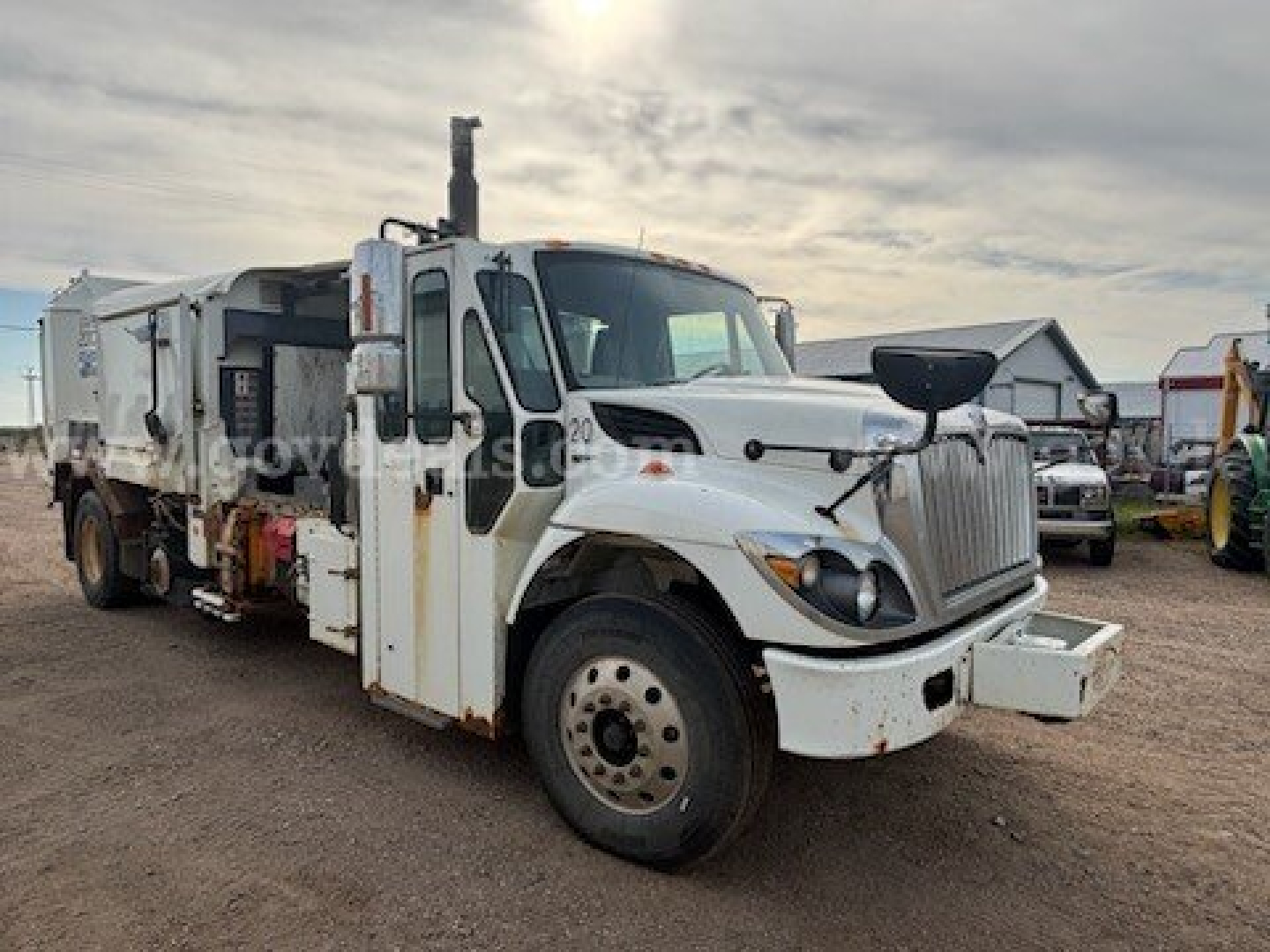 International 7400 dump truck in-service showing front-left side with white cab and dumping body.
