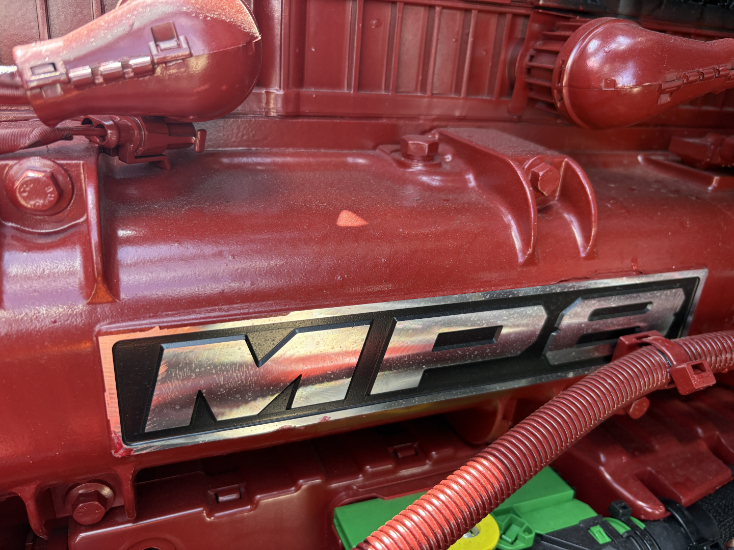 Mack engine bay showing MPI badge and red engine cover with wiring harness