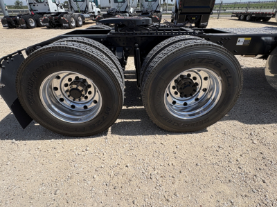 Dual rear tires on a Mack PI64T truck chassis showing tire tread and chrome rims; visible wheels and frame.
