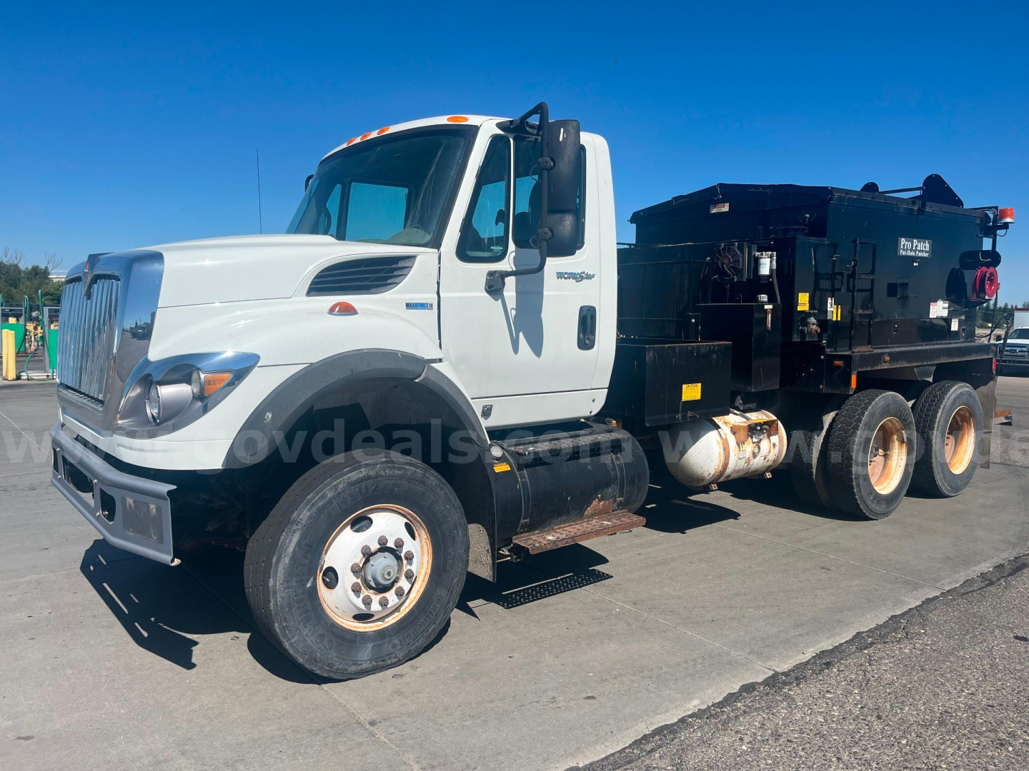 International WorkStar 7600 truck with asphalt hot oil unit, side view showing cab and storage tanks.