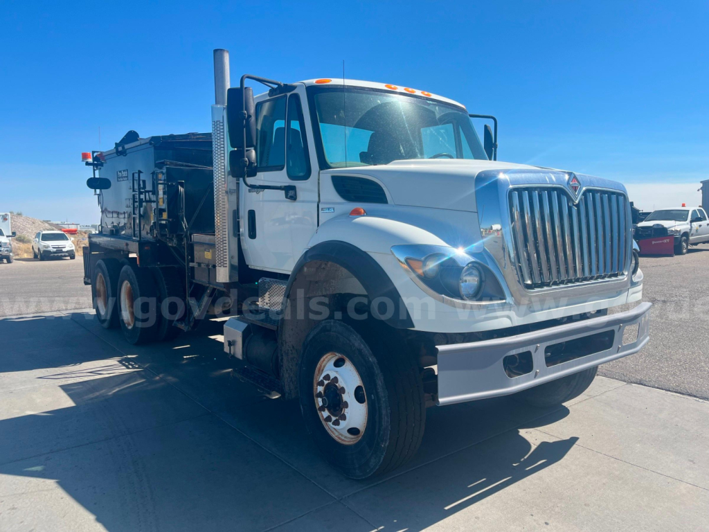 International WorkStar 7600 heavy truck in white, viewed from front-left, asphalt - hot oil service body, large grille, dual rear axles, service equipment mounted in bed.