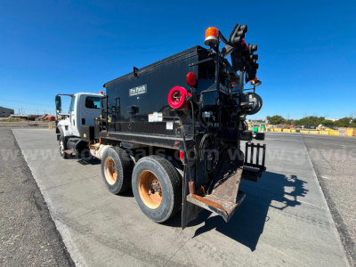 International WorkStar 7600 asphalt/maintenance truck rear view showing equipment hopper and rear-mounted hoses.