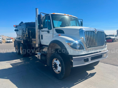 International WorkStar 7600 heavy truck in white, viewed from front-left, asphalt - hot oil service body, large grille, dual rear axles, service equipment mounted in bed.