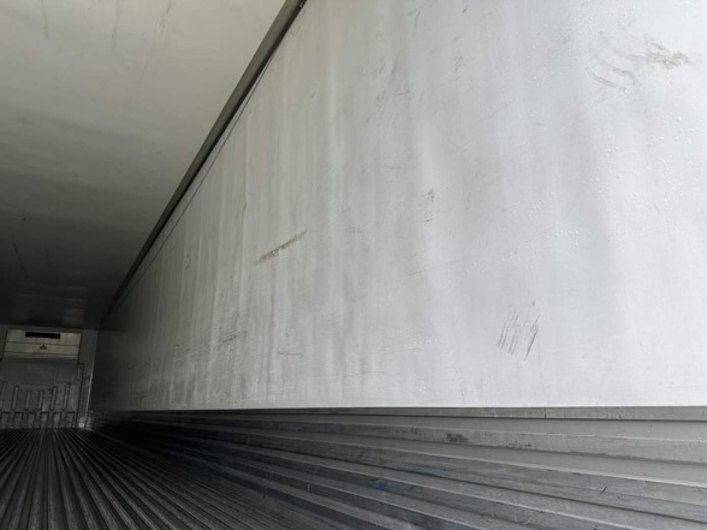2018 Utility 3000R trailer interior side wall with light markings and grime.