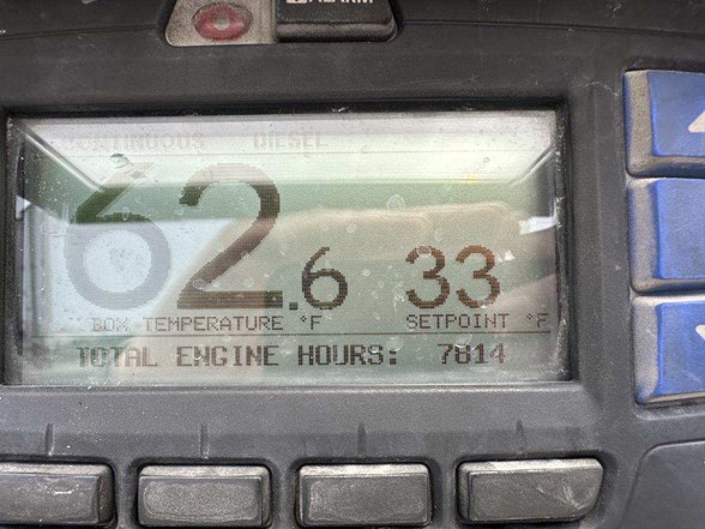 Truck trailer digital display showing engine hours and temperatures: 62.6 box temperature? 33 setpoint? total engine hours 7814. Fine print unreadable labels around.