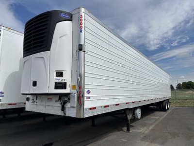 Utility 3000R trailer with Carrier refrigeration unit, side view showing white aluminum body, rear door, and landing gear.