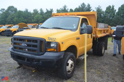 Ford F-350 Super Duty dump truck in yellow, front-left view showing TD612 on fender and dump bed elevated.