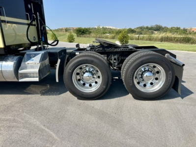 Kenworth W900L chassis with dual rear axles and chrome wheels, side view showing fuel tanks and cab step.