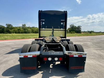 Kenworth truck rear view showing chassis and dual rear axles with mud flaps and taillights.