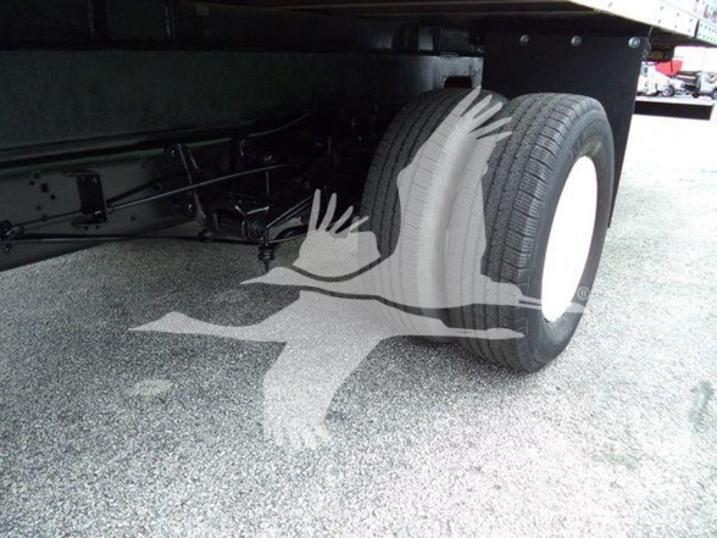 Rear wheel and undercarriage of a 2011 Ford E450 box truck showing dual rear tires and chassis components.