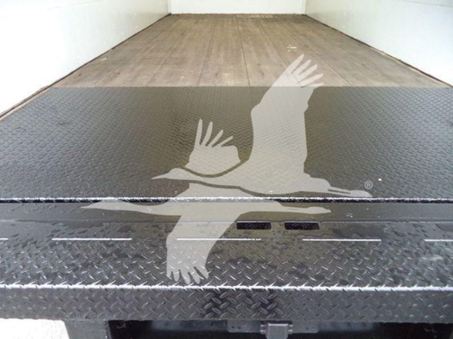 Ford E-450 box truck interior showing metal floor with diamond plate tread and loading ramp area.