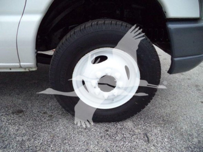 Vehicle wheel and tire on a Ford E450 box truck showing front wheel with white steel rim and black tire.