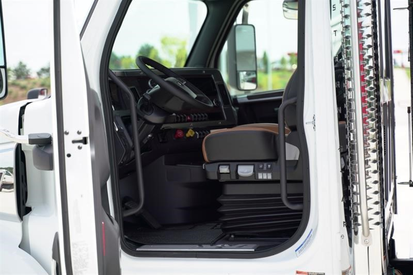 Western Star 47X truck cab interior with driver seat, steering wheel, and dashboard visible through open door.