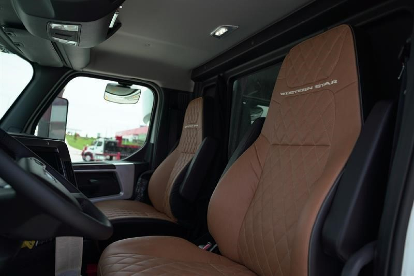 Interior cab of a Western Star 47X truck showing tan quilted seats and driver's seat with Western Star branding.