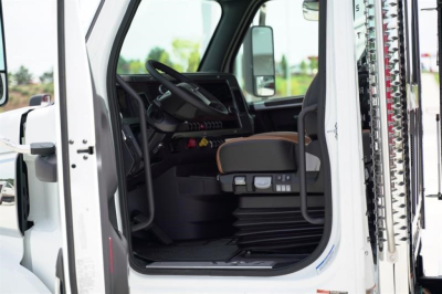 Western Star 47X truck cab interior with driver seat, steering wheel, and dashboard visible through open door.
