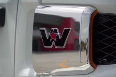 Front grille and emblem of a Western Star truck showing a chrome grille with a red-bordered opening and W star logo.