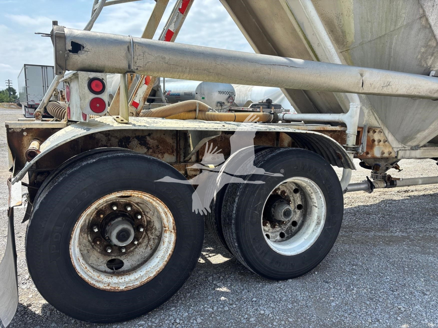 Dual rear wheels of a Fruehauf pneumatic dry bulk trailer showing rims, tires, and part of the frame with rusted hubs.