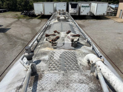 Fruehauf pneumatic dry bulk trailer top deck with access hatches and metal diamond plate, worn surface texture visible
