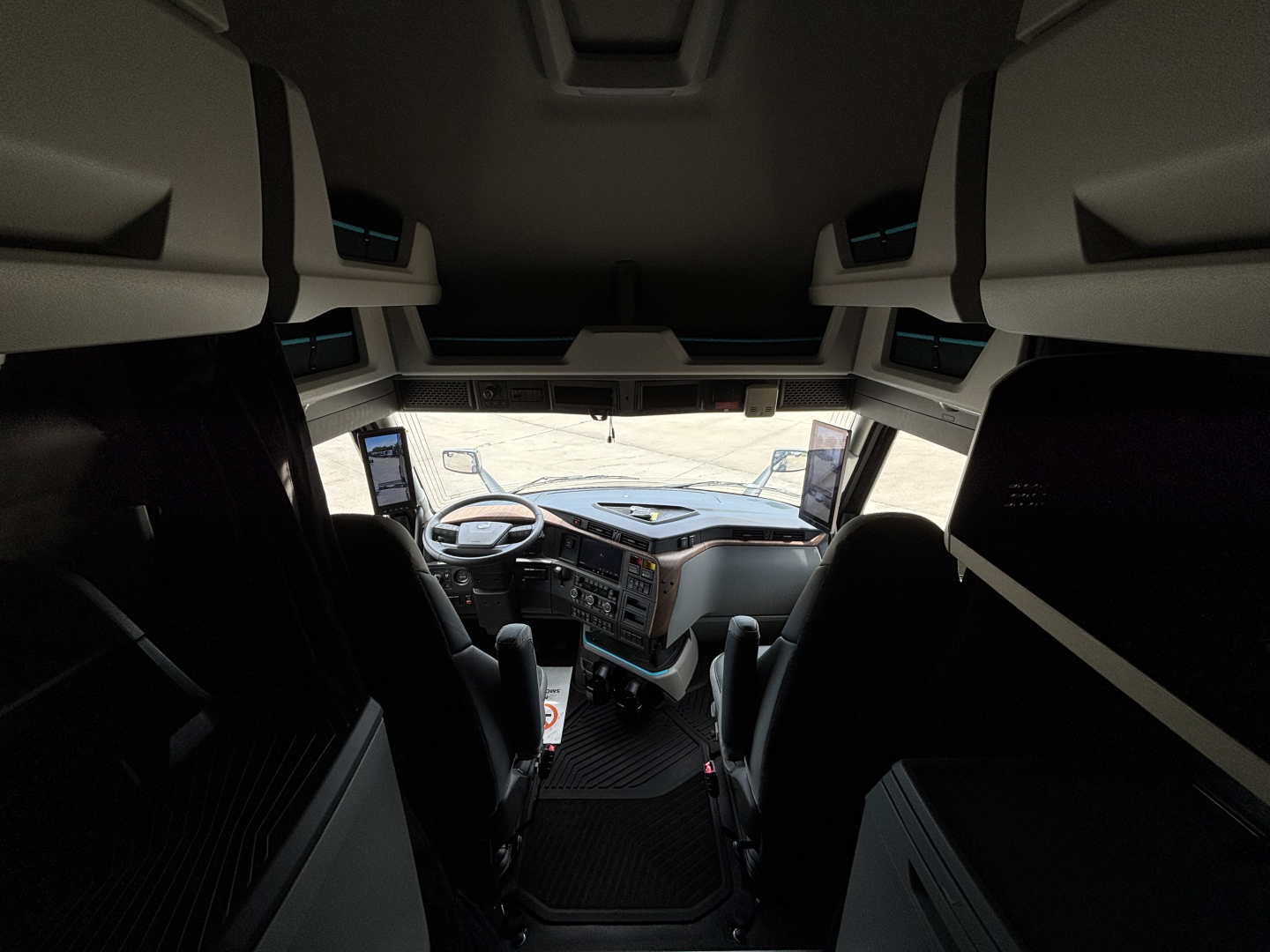  Volvo VNL cabin interior view from back of sleeper showing dashboard and overhead bunk storage panels.