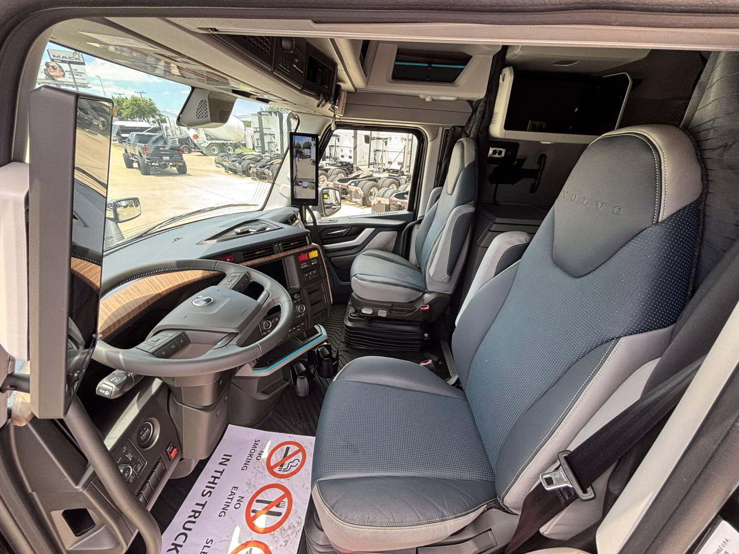 Volvo VNL64T860 truck interior showing steering wheel, driver seat, large dashboard, and bunk area in cab.