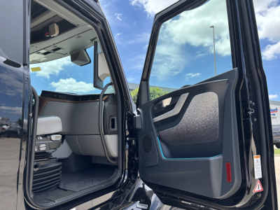 Volvo VNL64T860 cab interior with open doors, showing driver seat, dashboard area, and entry to sleeper cabin.