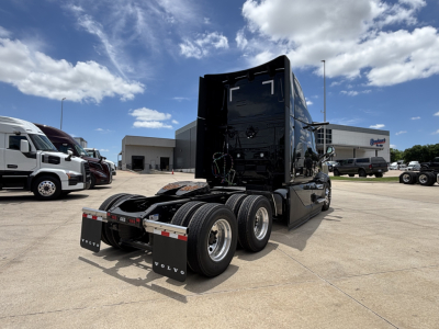 Volvo VNL64T860 truck in lot showing rear view and 6x4 tractor configuration with fifth wheel and rear mud flaps.