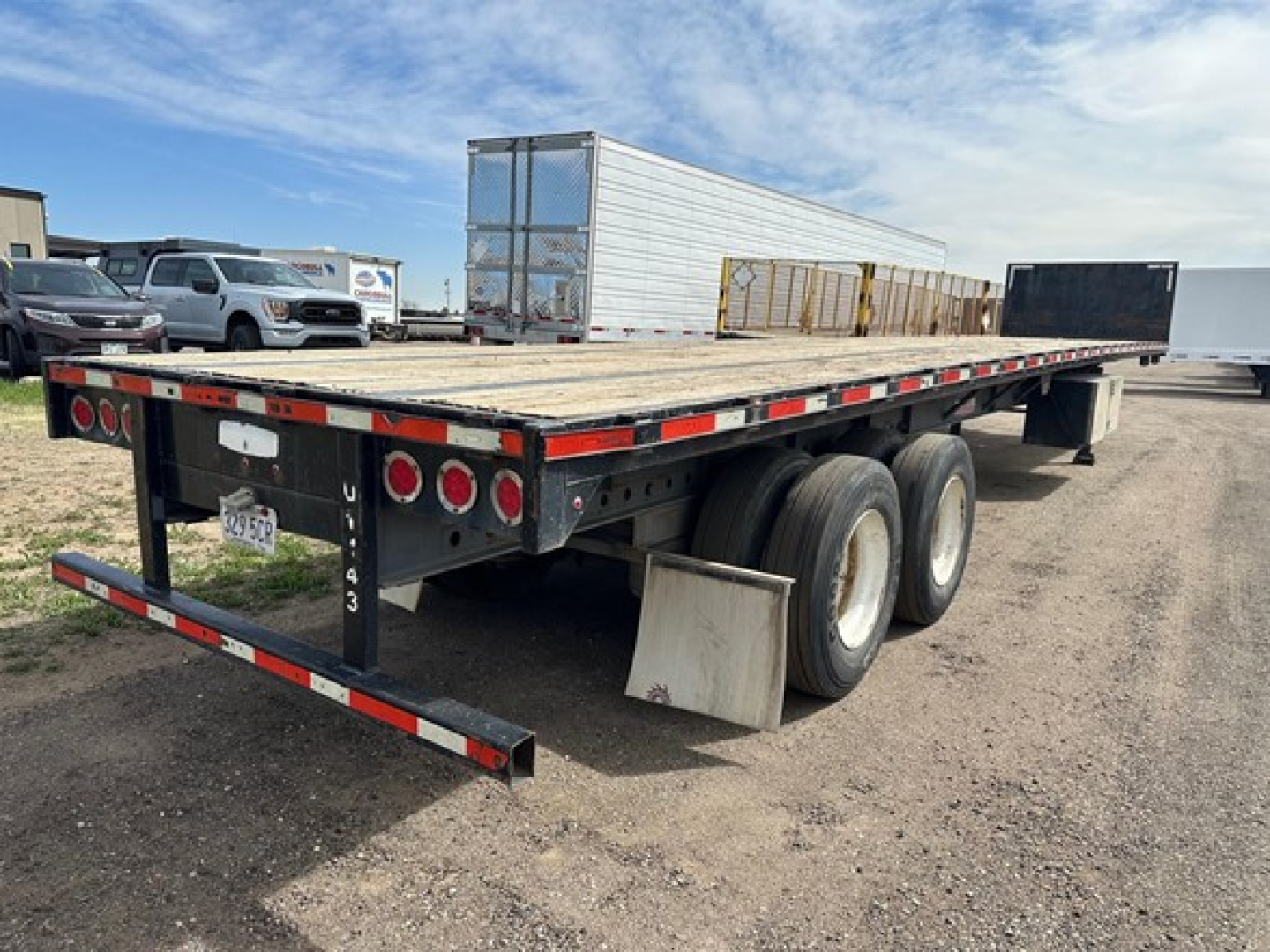 Trailer 2016 Clark Steel flatbed showing flatbed deck and dual rear axles with mudflaps and taillight bar.